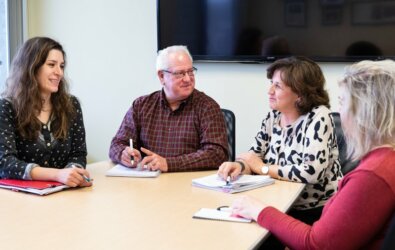 Photo of CareTeam managers gathered around a meeting table.