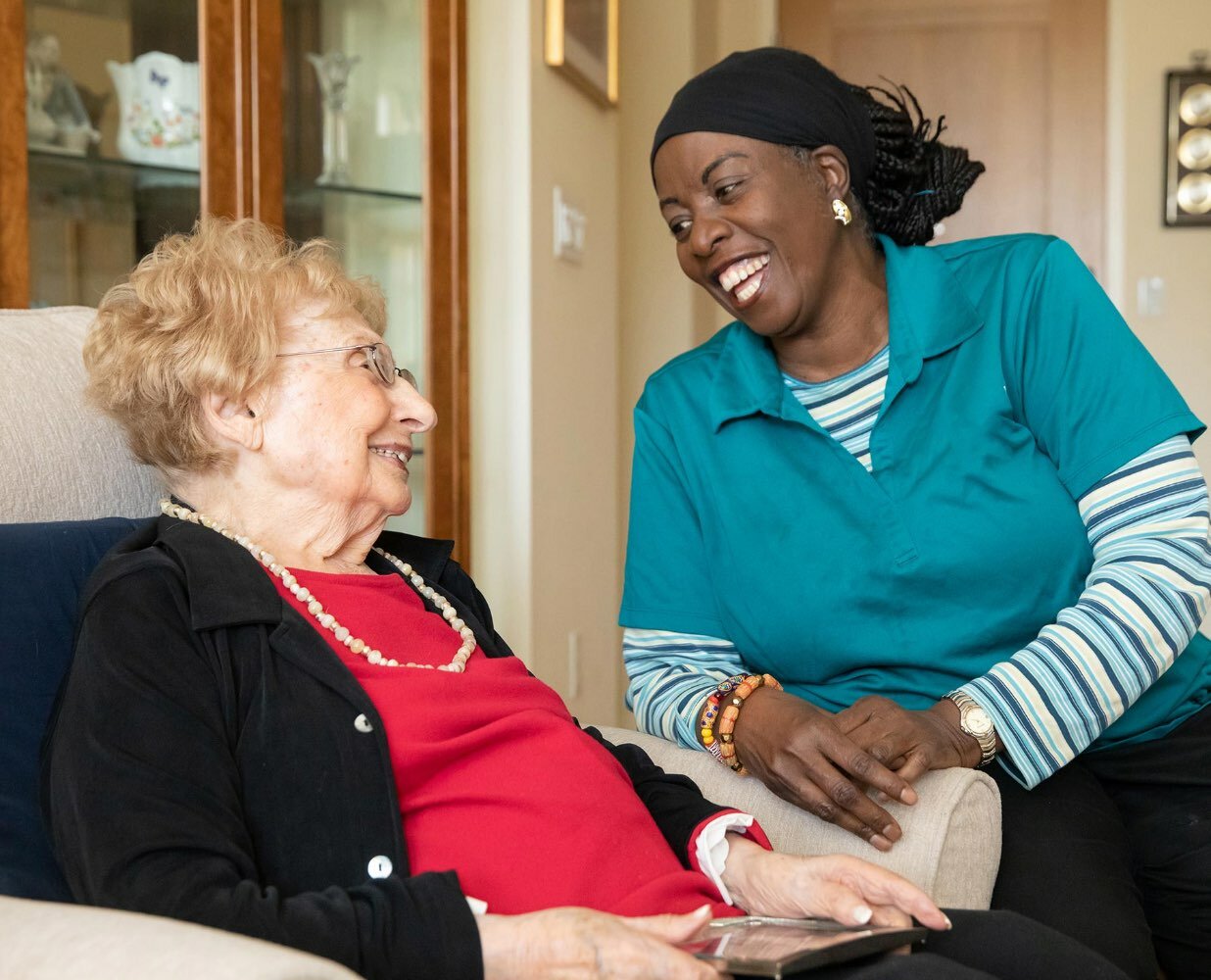 Photo of a Caring Friends employee laughing with a senior client.